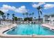 Sparkling community pool with lounge chairs and palm trees under a clear, sunny sky at 5267 81St N St # 8, St Petersburg, FL 33704