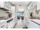 Bright galley style kitchen with white appliances, ample counter space and views of the living room at 5267 81St N St # 8, St Petersburg, FL 33704
