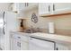 A view of the kitchen featuring a stainless sink, white cabinets and appliances and a wall decoration at 5267 81St N St # 8, St Petersburg, FL 33704