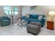 Cozy living room features tile flooring, bright natural light, blue sofa and accent chair at 5267 81St N St # 8, St Petersburg, FL 33704