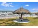Inviting outdoor seating area with a thatched umbrella and white picket fence under a sunny sky at 5267 81St N St # 8, St Petersburg, FL 33704