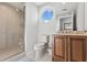 Bright bathroom featuring a glass shower, and vanity with wood cabinetry at 5823 Bowen Daniel Dr # 906, Tampa, FL 33616