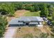 Aerial view of home with a large yard, a car port, a screened-in porch, and mature trees at 592 Ken Hubbard Rd, Terra Ceia, FL 34250