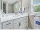 Updated bathroom boasts a vanity with solid surface countertop, updated fixtures and large mirror at 592 Ken Hubbard Rd, Terra Ceia, FL 34250