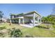 Side view of a two-story home with an attached boat carport and a young palm tree at 592 Ken Hubbard Rd, Terra Ceia, FL 34250