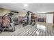 Large exercise room with modern workout equipment, wood-look flooring, and neutral paint at 592 Ken Hubbard Rd, Terra Ceia, FL 34250