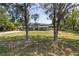 Inviting two-story home with lush front lawn and covered parking, framed by mature trees and ample space at 592 Ken Hubbard Rd, Terra Ceia, FL 34250