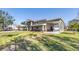 Side view of a two-story home featuring an attached boat carport and well-maintained lawn, complemented by a clear blue sky at 592 Ken Hubbard Rd, Terra Ceia, FL 34250