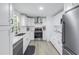 Modern white kitchen with stainless steel appliances, sleek countertops, and ample cabinet space at 592 Ken Hubbard Rd, Terra Ceia, FL 34250