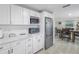 Modern kitchen featuring white cabinetry and stainless appliances near the dining area at 592 Ken Hubbard Rd, Terra Ceia, FL 34250