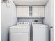 Laundry room with white washer, dryer, and upper cabinets for easy storage at 6507 61St E Dr, Palmetto, FL 34221
