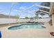 Screened-in pool featuring a white fence, landscaping, and patio furniture at 6507 61St E Dr, Palmetto, FL 34221