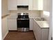Updated kitchen with stainless steel appliances, white cabinets, and granite countertops at 7319 Holiday Dr, Spring Hill, FL 34606