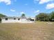 Quaint single story home with stone bench seating, green grass, and mature trees at 7346 Hiawatha Pkwy, Spring Hill, FL 34606