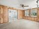 Sunlit bonus room featuring wood-paneled walls and sliding glass door access at 7346 Hiawatha Pkwy, Spring Hill, FL 34606