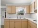 Bright kitchen offers light wood cabinets, white countertops and a double stainless steel sink at 7346 Hiawatha Pkwy, Spring Hill, FL 34606