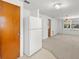 Eat-in kitchen with white refrigerator and view of the dining space via a sliding glass door at 7346 Hiawatha Pkwy, Spring Hill, FL 34606