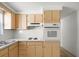 Classic galley kitchen with modern white appliances, blonde wood cabinets and bright, white countertops at 7346 Hiawatha Pkwy, Spring Hill, FL 34606