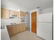 Compact kitchen features blonde wood cabinets, laminate countertops and modern white appliances at 7346 Hiawatha Pkwy, Spring Hill, FL 34606
