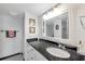 Elegant bathroom with a sleek black granite countertop, vanity, and mirror, adding a touch of luxury at 7400 Sun Island S Dr # 206, South Pasadena, FL 33707