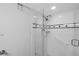 Modern shower with white tile, black accents, grab bars, and a glass door for a sleek design at 7400 Sun Island S Dr # 206, South Pasadena, FL 33707