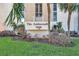 Signage for The Ambassador 7400 amidst lush greenery and palm trees at 7400 Sun Island S Dr # 206, South Pasadena, FL 33707