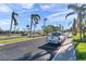 Street view with palm trees and cars under a blue sky at 7400 Sun Island S Dr # 206, South Pasadena, FL 33707