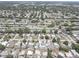 This aerial shot captures a neighborhood with well-maintained homes, a pond, and lush greenery and mature trees at 8358 Candlewood Rd, Seminole, FL 33777