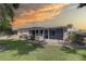 Manicured backyard with lush lawn, screened lanai, and a concrete patio area at 8358 Candlewood Rd, Seminole, FL 33777