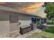 Exterior of house with backyard featuring an AC unit and closed in porch with a beautiful sunset at 8358 Candlewood Rd, Seminole, FL 33777