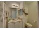 Well-lit bathroom featuring a vanity with sink, mirror, and toilet with storage at 8358 Candlewood Rd, Seminole, FL 33777