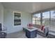 Relaxing sunroom featuring a cozy couch with pillows and bright outdoor views at 8358 Candlewood Rd, Seminole, FL 33777