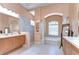 Bright primary bathroom with a soaking tub, walk-in shower, dual vanities and luxurious finishes at 8474 Dunham Station Dr, Tampa, FL 33647