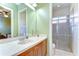 Bathroom featuring a shower and vanity, with a view of the bedroom and ample lighting at 8474 Dunham Station Dr, Tampa, FL 33647