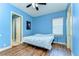 Bright blue bedroom with a ceiling fan, window, and ensuite bathroom, offering cozy living at 8474 Dunham Station Dr, Tampa, FL 33647