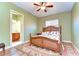 Bedroom with a decorative rug, a ceiling fan, a window, and an en suite bathroom at 8474 Dunham Station Dr, Tampa, FL 33647
