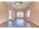 Comfortable peach bedroom with hardwood flooring and natural light from two large windows and a door at 8474 Dunham Station Dr, Tampa, FL 33647