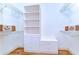 Walk-in closet featuring a wood floor, shelving, cabinets, and drawers for ample storage at 8474 Dunham Station Dr, Tampa, FL 33647