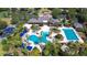 Aerial view of a community pool and clubhouse surrounded by lush landscaping and palm trees at 8474 Dunham Station Dr, Tampa, FL 33647