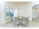Bright dining room featuring a glass table, modern lighting, and a large window view of the pool area at 8474 Dunham Station Dr, Tampa, FL 33647