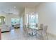Open concept dining area with a glass table, modern chandelier, and pool views from the adjacent living space at 8474 Dunham Station Dr, Tampa, FL 33647