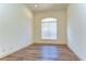 Bright, empty room with wood floors, a large window, and simple finishes, perfect for an office at 8474 Dunham Station Dr, Tampa, FL 33647