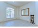 Neutral living room with tile floors, a window with blinds, and a mirror adding a touch of elegance to the space at 8474 Dunham Station Dr, Tampa, FL 33647