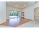 Spacious living room featuring hardwood floors, natural light, with views of the screened pool and backyard at 8474 Dunham Station Dr, Tampa, FL 33647