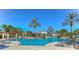 Expansive community pool area with lounge chairs and sunshades under a clear blue sky, perfect for relaxation at 8474 Dunham Station Dr, Tampa, FL 33647