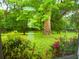 Backyard view of creek surrounded by lush greenery and trees from inside the house at 8600 Village Mill Row, Hudson, FL 34667