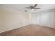 Neutral bedroom featuring a ceiling fan, carpet, and closet space at 8600 Village Mill Row, Hudson, FL 34667