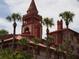 Exterior view of a historic building with red tile and palm trees at 8600 Village Mill Row, Hudson, FL 34667