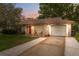 Charming home featuring a well-manicured front lawn, attached garage, and a cozy front porch at 8600 Village Mill Row, Hudson, FL 34667