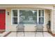 Inviting front porch with seating area and a vibrant red door at 8600 Village Mill Row, Hudson, FL 34667